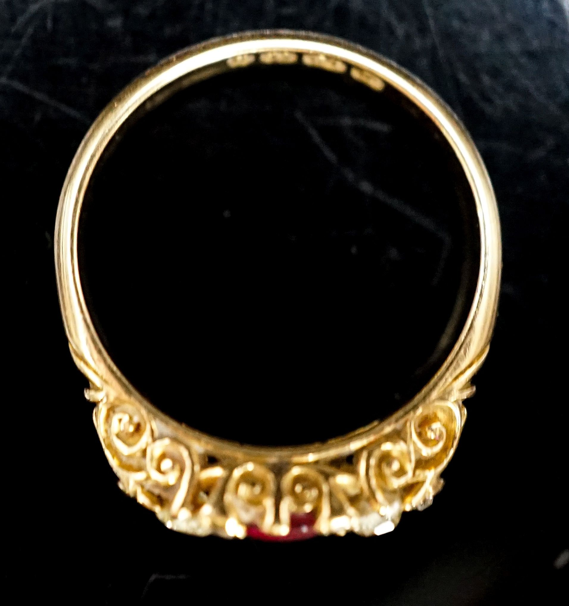 An Edwardian 18ct gold, ruby and diamond three stone ring, with diamond chip spacers (one missing), size N, gross weight 3.3 grams.